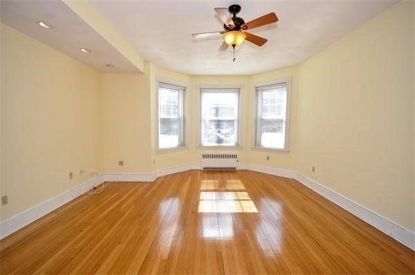 96 St Paul Street, Unit 2 Brookline, MA 02446 - Photo 2 of 14 an empty room with wooden floor fan and windows