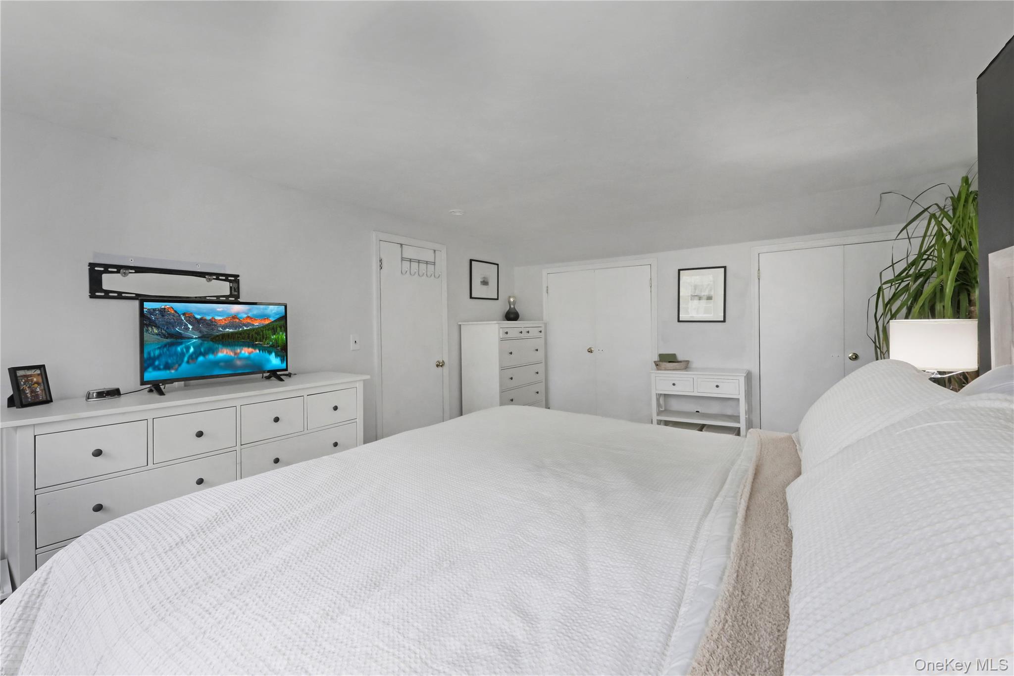48 Nidzyn Avenue Remsenburg, NY 11960 - Photo 31 of 43 a bedroom with a bed a window and potted plant