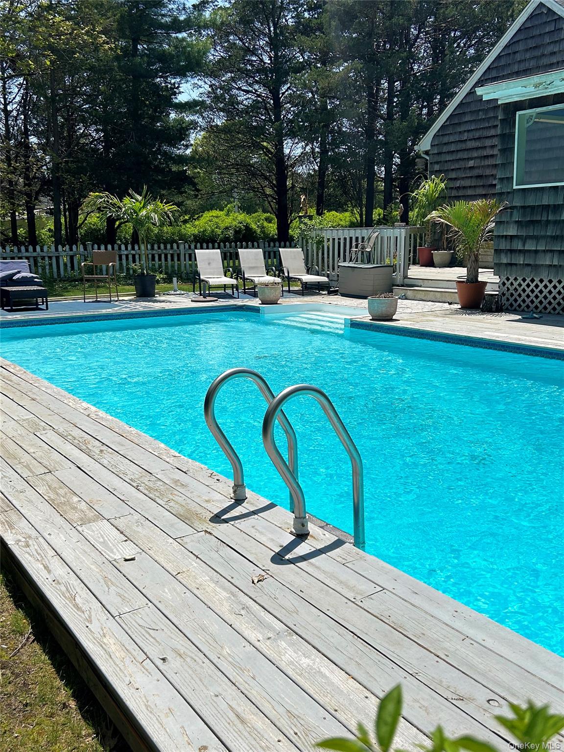 48 Nidzyn Avenue Remsenburg, NY 11960 - Photo 39 of 43 a view of a swimming pool with a bench and trees