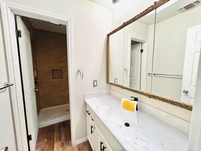 an empty room with a chandelier fan and windows