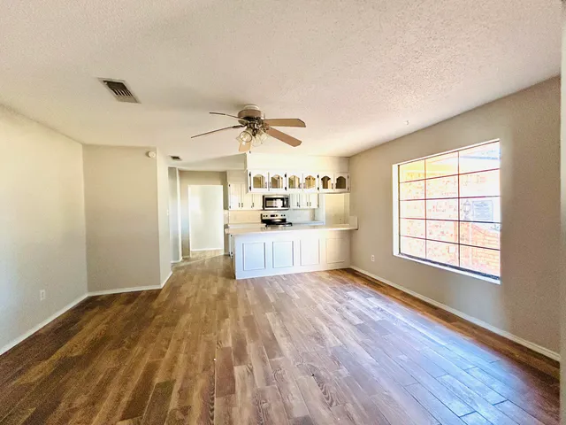 a view of a kitchen with wooden floor and a window