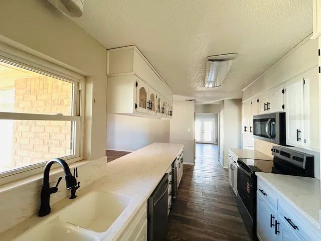 a kitchen with a stove a sink and a refrigerator