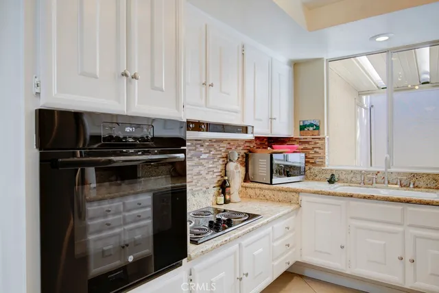 a kitchen with white cabinets and refrigerator