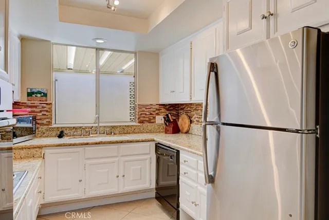 a kitchen with white cabinets and appliances
