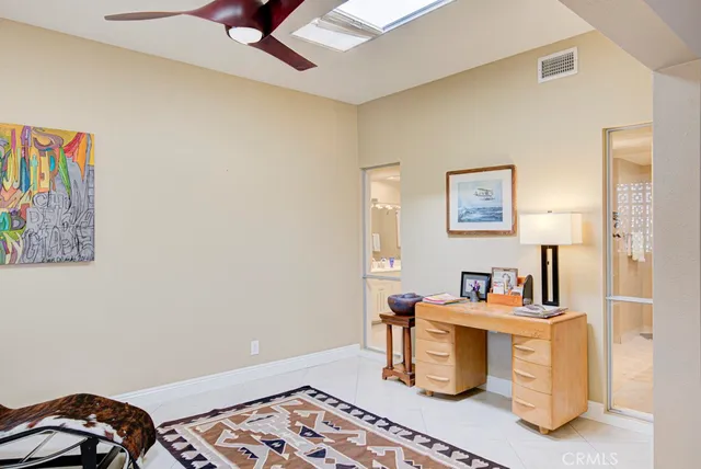 a view of a workspace with furniture and a window