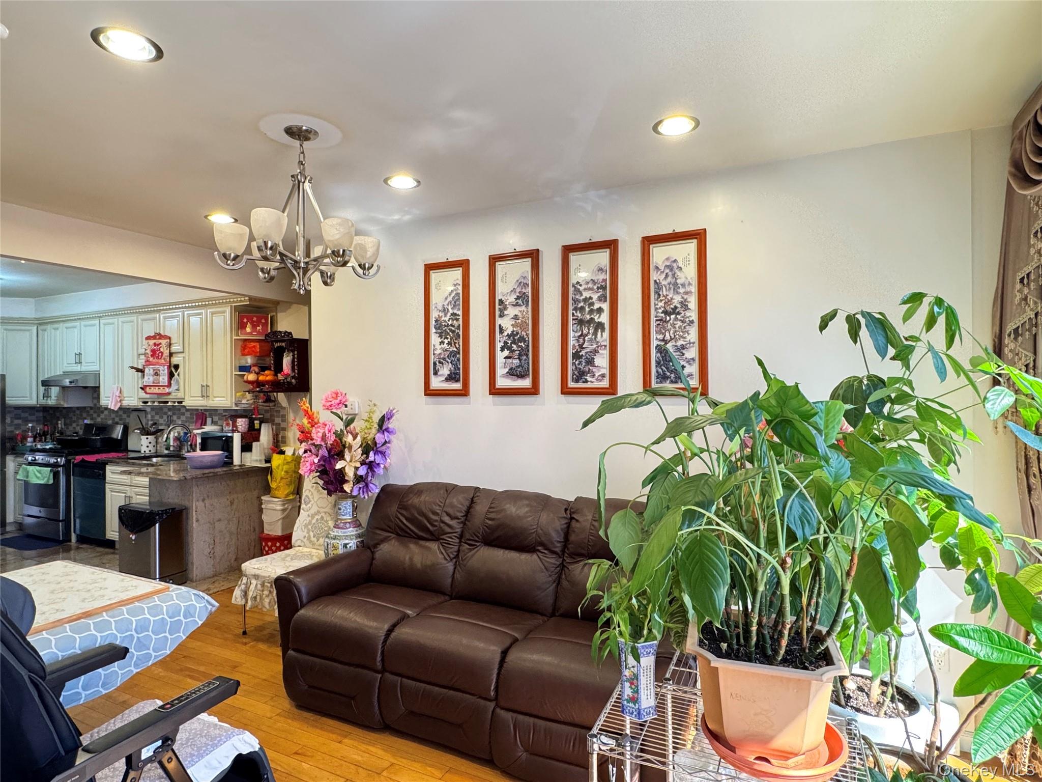 42-16 162nd Street Queens, NY 11358 - Photo 3 of 16 Living area featuring light wood finished floors, recessed lighting, and a chandelier