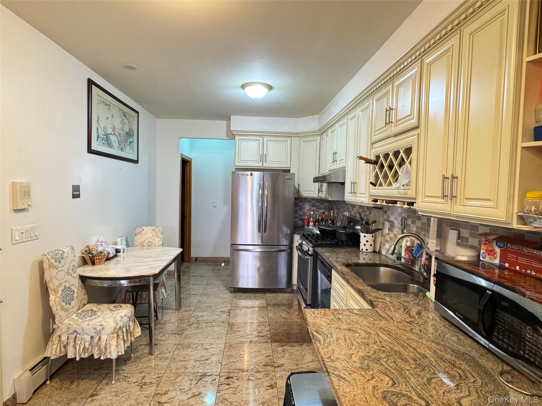42-16 162nd Street Queens, NY 11358 - Photo 5 of 16 Kitchen with stainless steel appliances, decorative backsplash, dark stone counters, open shelves, and cream cabinetry