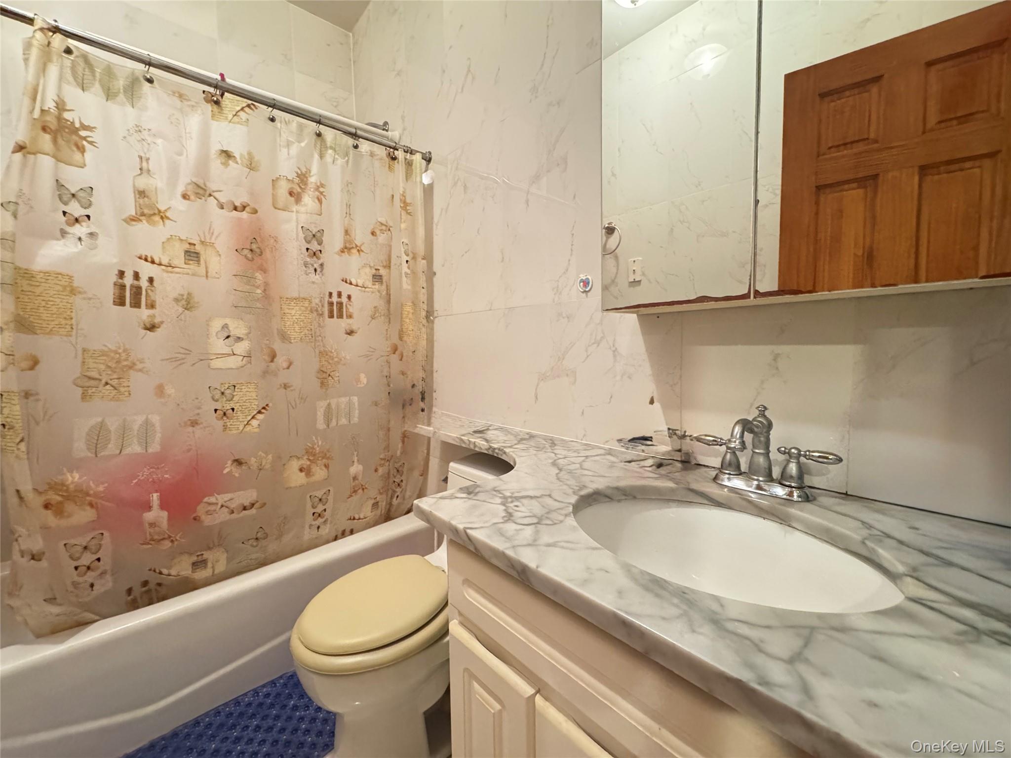 42-16 162nd Street Queens, NY 11358 - Photo 6 of 16 Full bathroom with shower / bath combo, vanity, and tile walls
