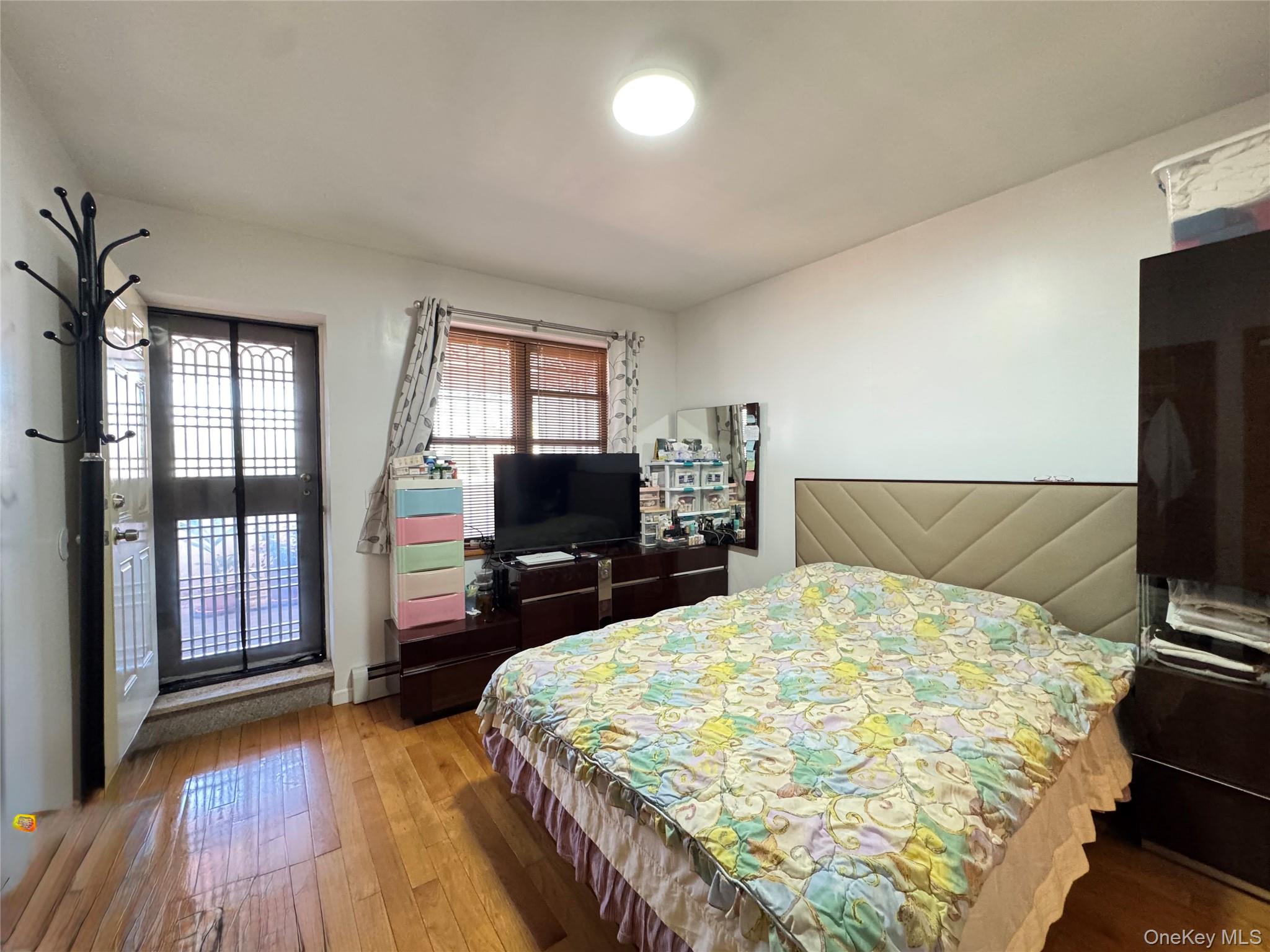 42-16 162nd Street Queens, NY 11358 - Photo 8 of 16 Bedroom with hardwood / wood-style flooring and a baseboard heating unit