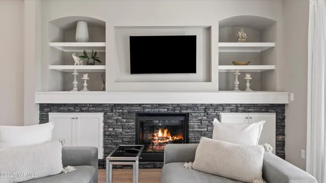 a living room with furniture a fireplace and a flat screen tv