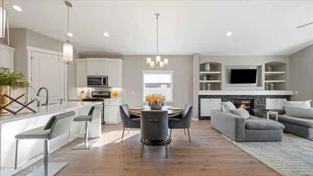 a kitchen with stainless steel appliances a stove a microwave a sink a refrigerator and a white cabinets