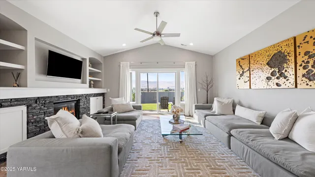 a living room with furniture floor to ceiling window and a flat screen tv