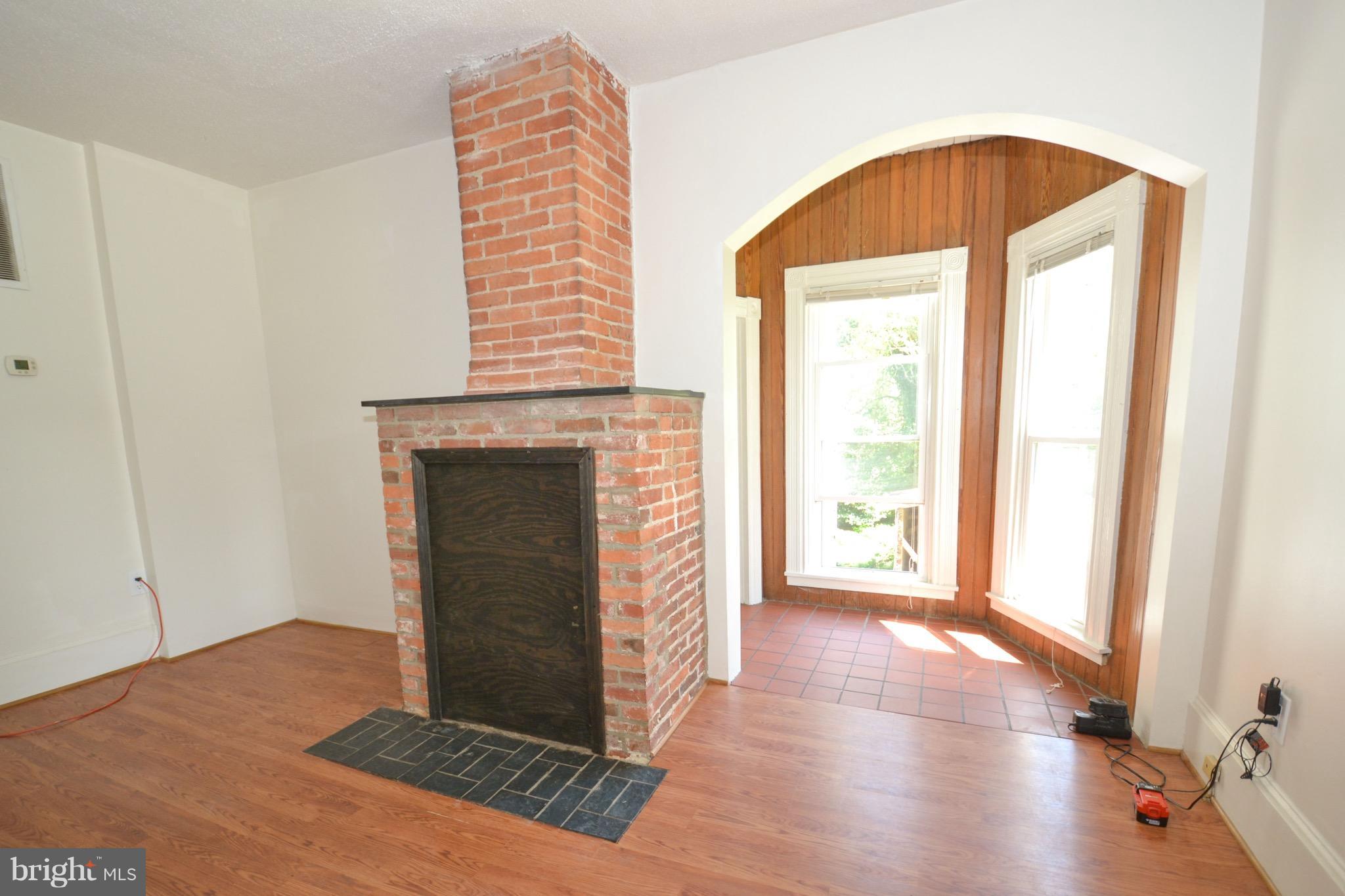 374 Jewell Road Dunkirk, MD 20754 - Photo 14 of 25 a view of an empty room with exposed radiator and a fireplace