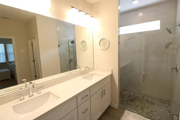 a bathroom with a double vanity sink mirror and shower