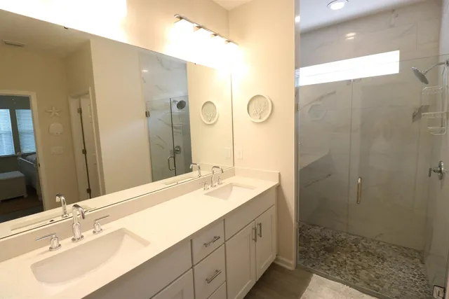 a bathroom with a double vanity sink mirror and shower