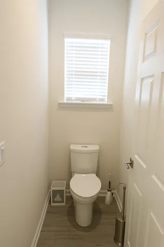 a white toilet sitting in a bathroom next to a window