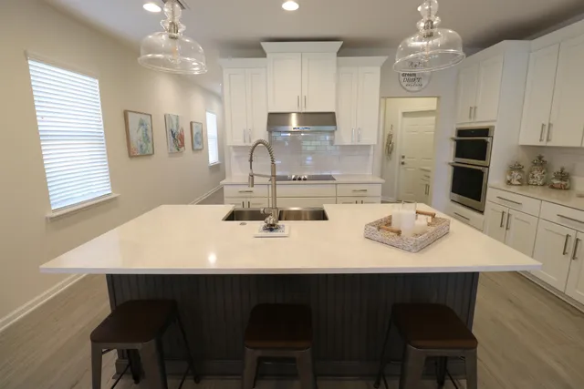 a kitchen with stainless steel appliances kitchen island granite countertop a kitchen island and chairs in it