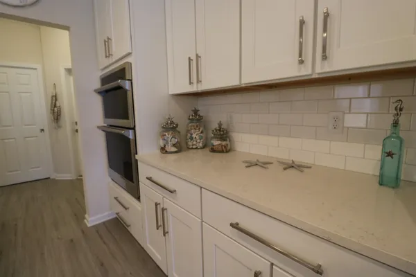 a kitchen with stainless steel appliances white cabinets and a refrigerator