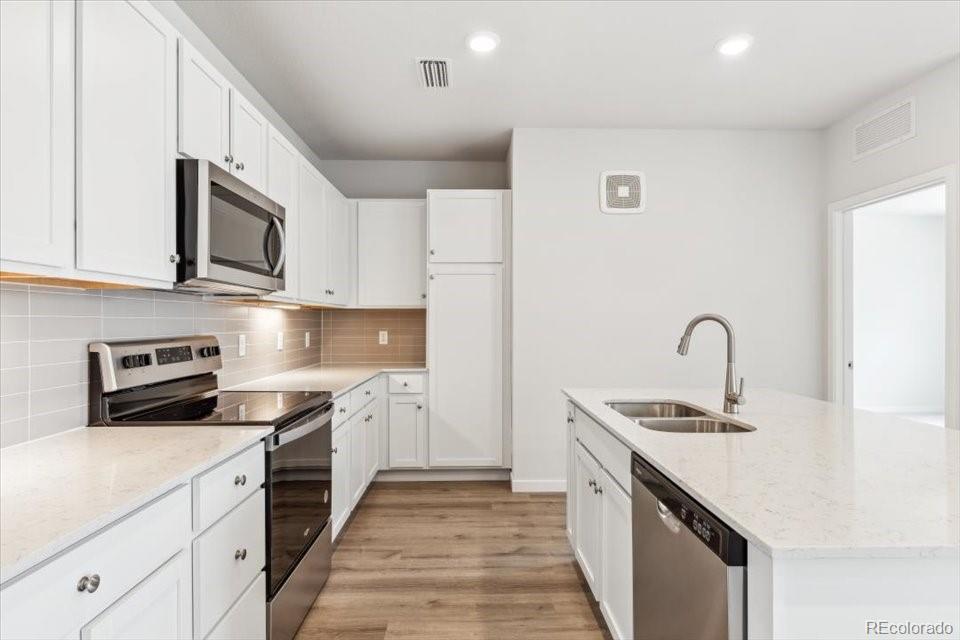 485 Interlocken Boulevard, Unit 210 Broomfield, CO 80021 - Photo 4 of 15 a kitchen with stainless steel appliances granite countertop a sink and stove top oven