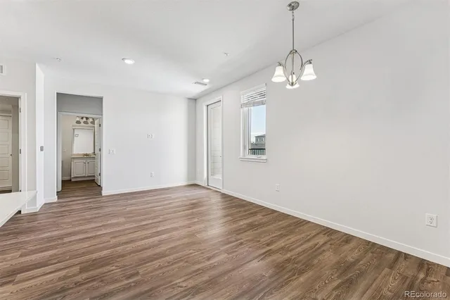 a view of empty room with wooden floor and ceiling fan