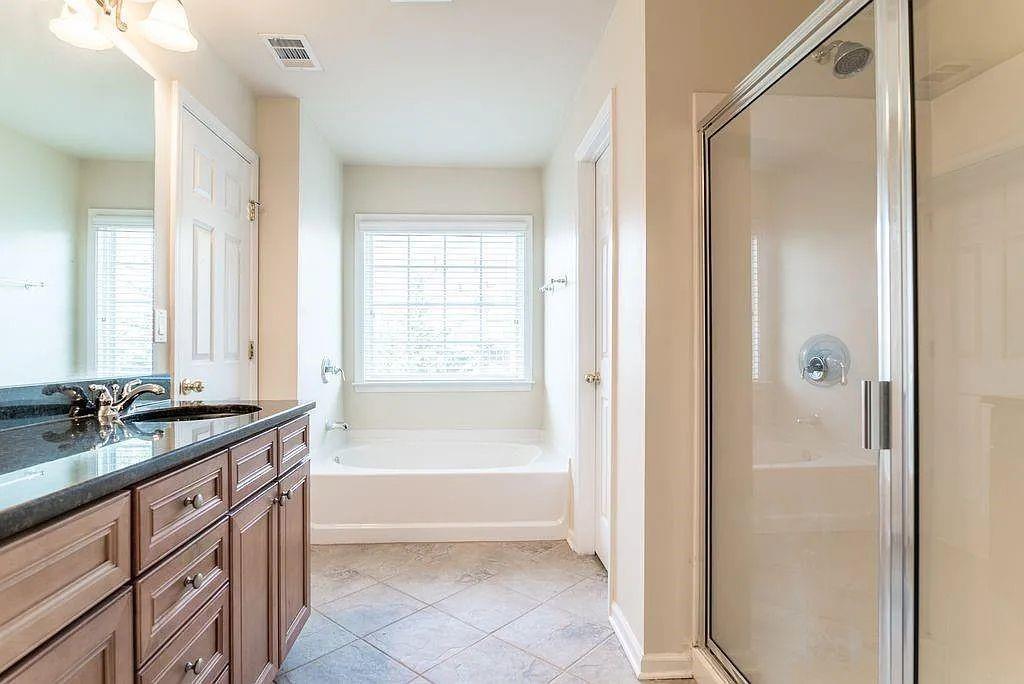 6120 Joybrook Road Duluth, GA 30097 - Photo 19 of 30 a bathroom with a granite countertop sink mirror bathtub and next to a window