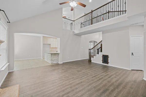 a view of empty room with stairs and a chandelier