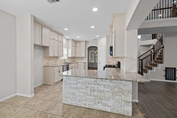 a large kitchen with kitchen island a counter top stainless steel appliances and cabinets