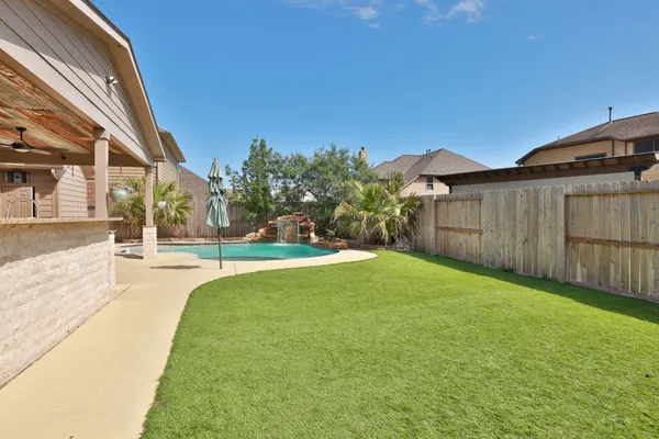 a view of a house with backyard and a patio