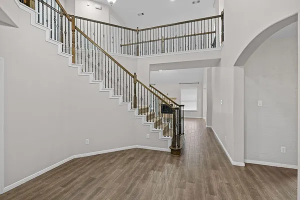 a view of staircase with wooden floor and white walls