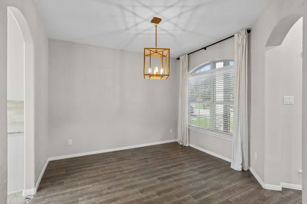 a view of a hallway with wooden floor and a window