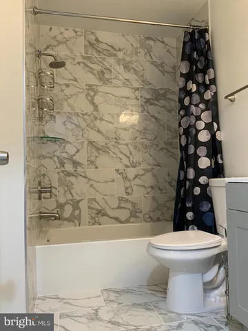 a bathroom with a toilet and a shower curtain