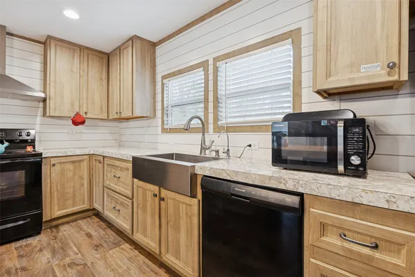 a kitchen with stainless steel appliances granite countertop a sink a stove and cabinets
