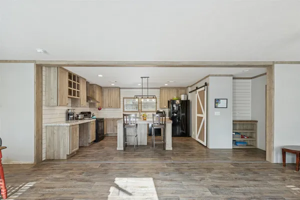 a view of a kitchen with refrigerator and window
