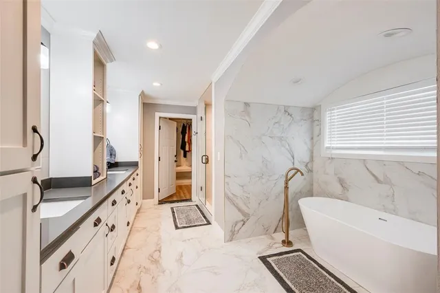 a spacious bathroom with a tub sink and mirror