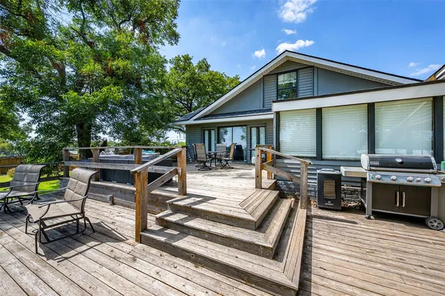 a view of a roof deck with wooden chairs and a table
