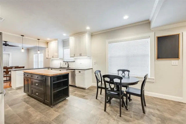 a kitchen with a stove a table and chairs in it