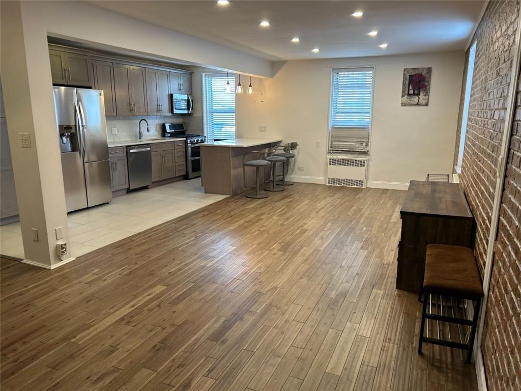 2232 Brigham Street, Unit 2K Brooklyn, NY 11229 - Photo 1 of 14 a kitchen with stainless steel appliances wooden floor and refrigerator