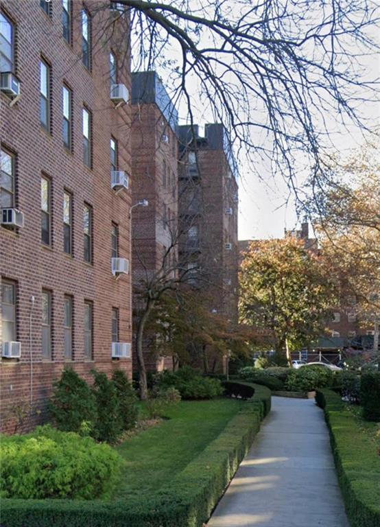 2232 Brigham Street, Unit 2K Brooklyn, NY 11229 - Photo 12 of 14 a view of a brick building next to a yard
