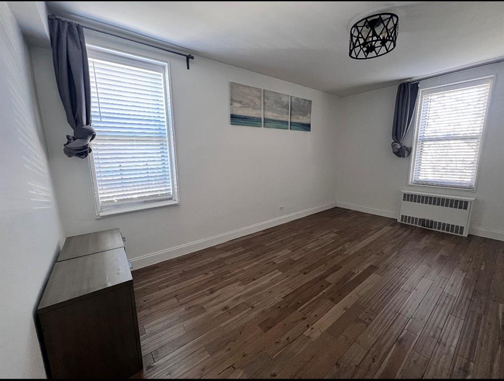 2232 Brigham Street, Unit 2K Brooklyn, NY 11229 - Photo 7 of 14 a view of an empty room with wooden floor and a window