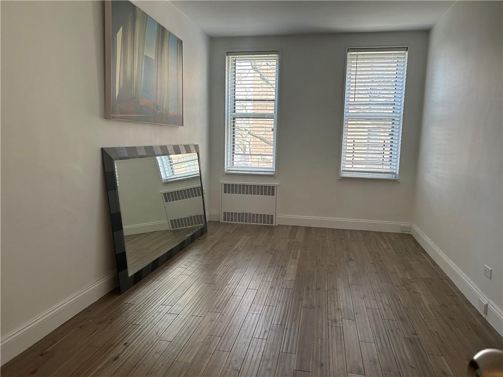 2232 Brigham Street, Unit 2K Brooklyn, NY 11229 - Photo 9 of 14 an empty room with wooden floor and windows