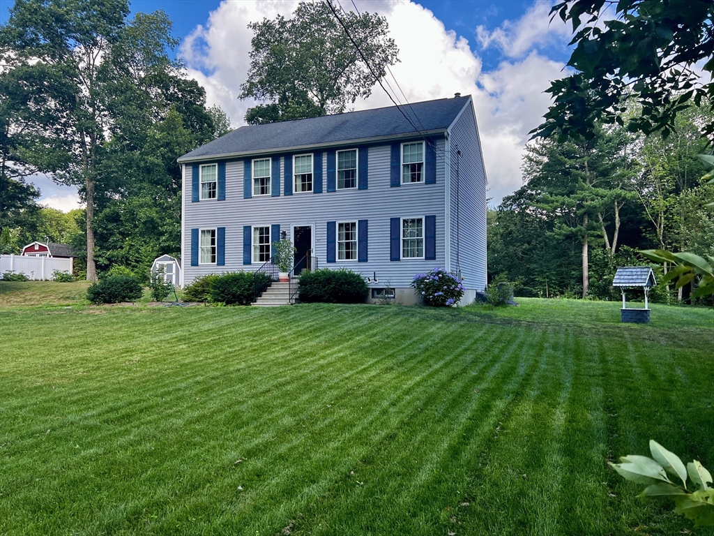a front view of a house with a yard and trees