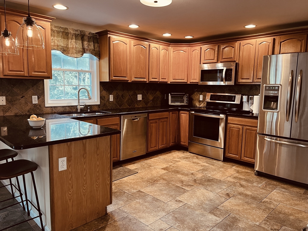 97 Breakneck Road Sturbridge, MA 01566 - Photo 11 of 33 a kitchen with stainless steel appliances granite countertop a stove top oven a sink and dishwasher