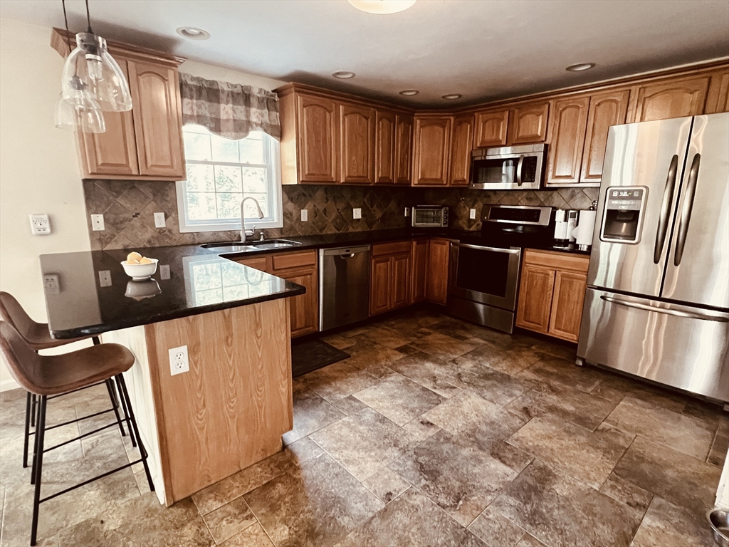 97 Breakneck Road Sturbridge, MA 01566 - Photo 10 of 33 a kitchen with granite countertop a refrigerator stove top oven and sink