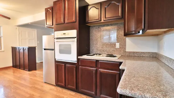 a kitchen with stainless steel appliances granite countertop a refrigerator a stove and a sink