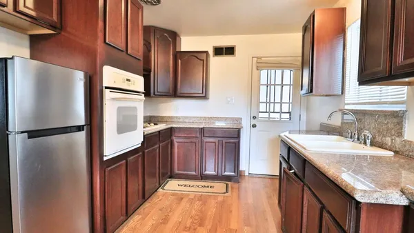 a kitchen with granite countertop a refrigerator and a sink