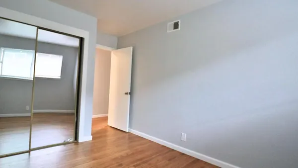 a view of an empty room with wooden floor