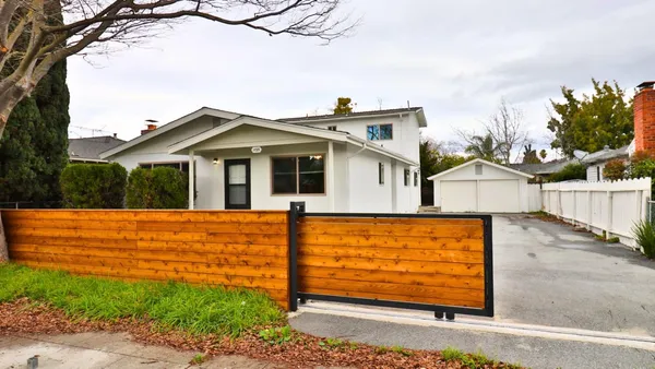a view of a house with a wooden fence