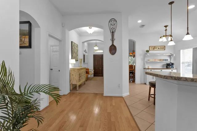 a bedroom with a bed chandelier and a window