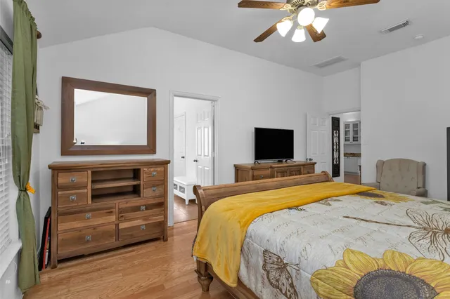 a bedroom with a bed and a lamp on dresser