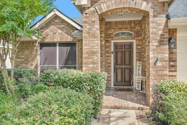 front view of a brick house with a small yard